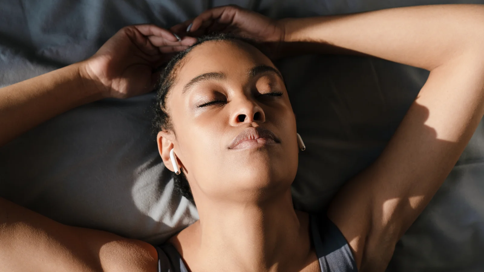 Sportive allongée sur son lit, les yeux fermés, en pleine récupération
