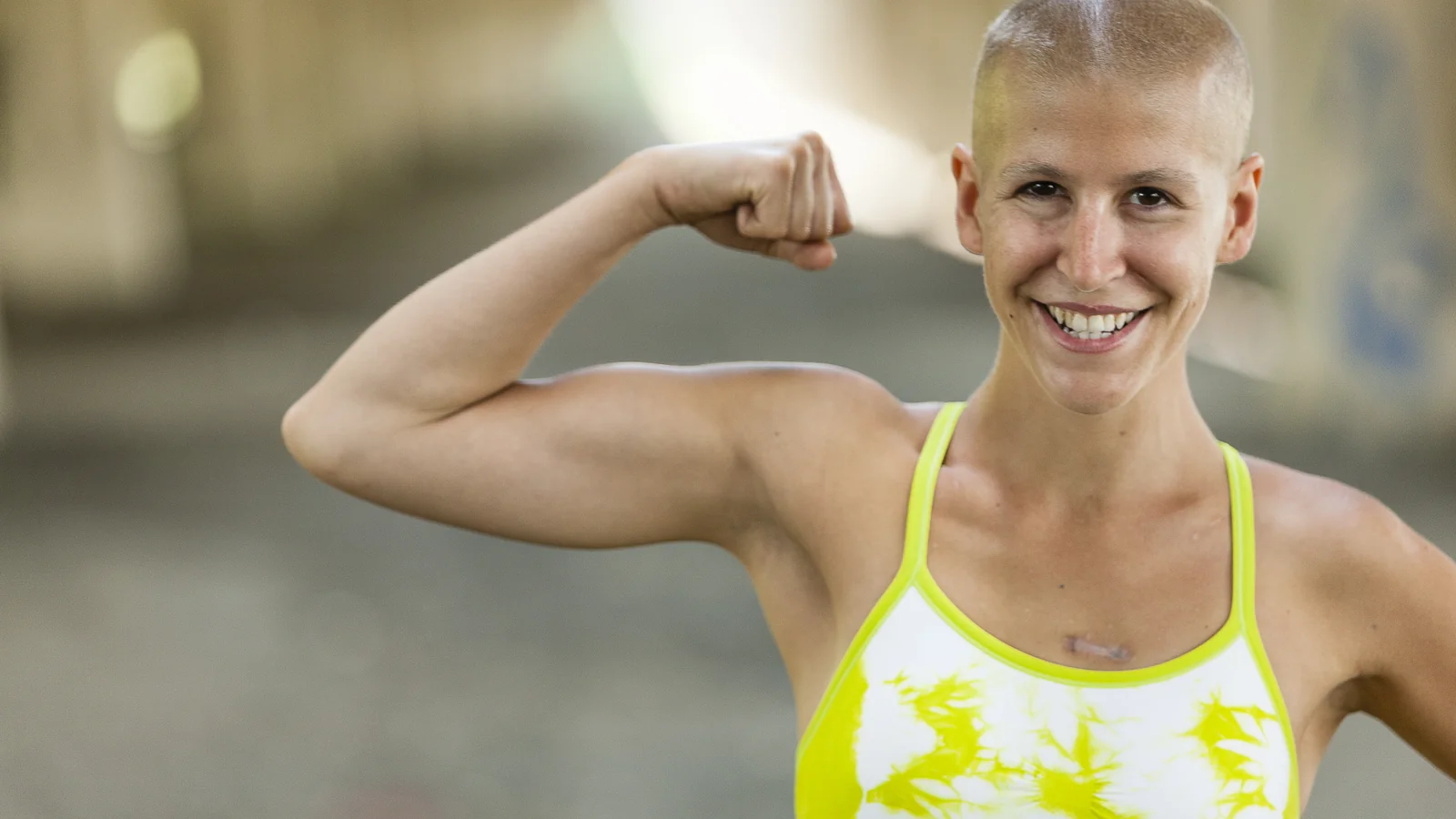 Femme souriante en pleine reprise sportive après une maladie, montrant sa force retrouvée